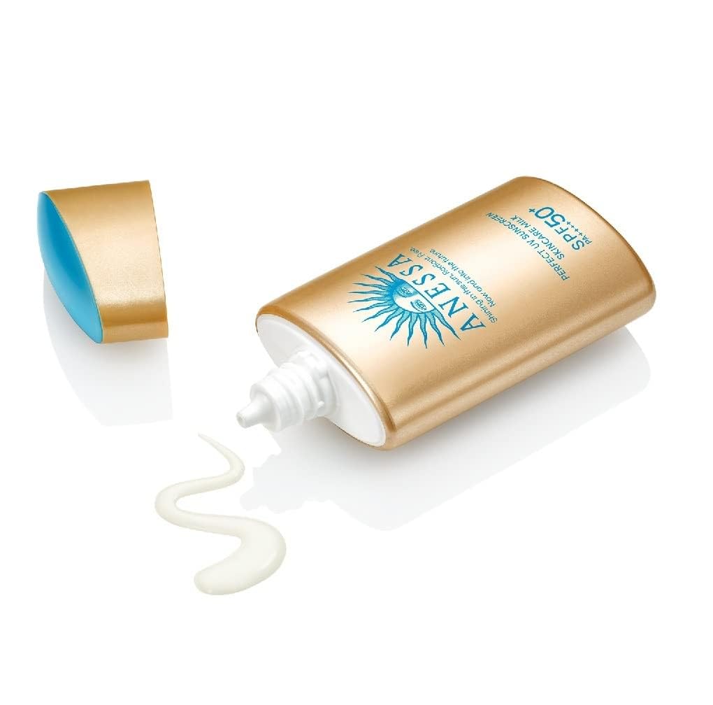 Top 10 Best Sunscreen for all skin types Anessa sunscreen bottle photographed beside a folded beach towel and seashells in bright sunlight for outdoor SPF lifestyle scene