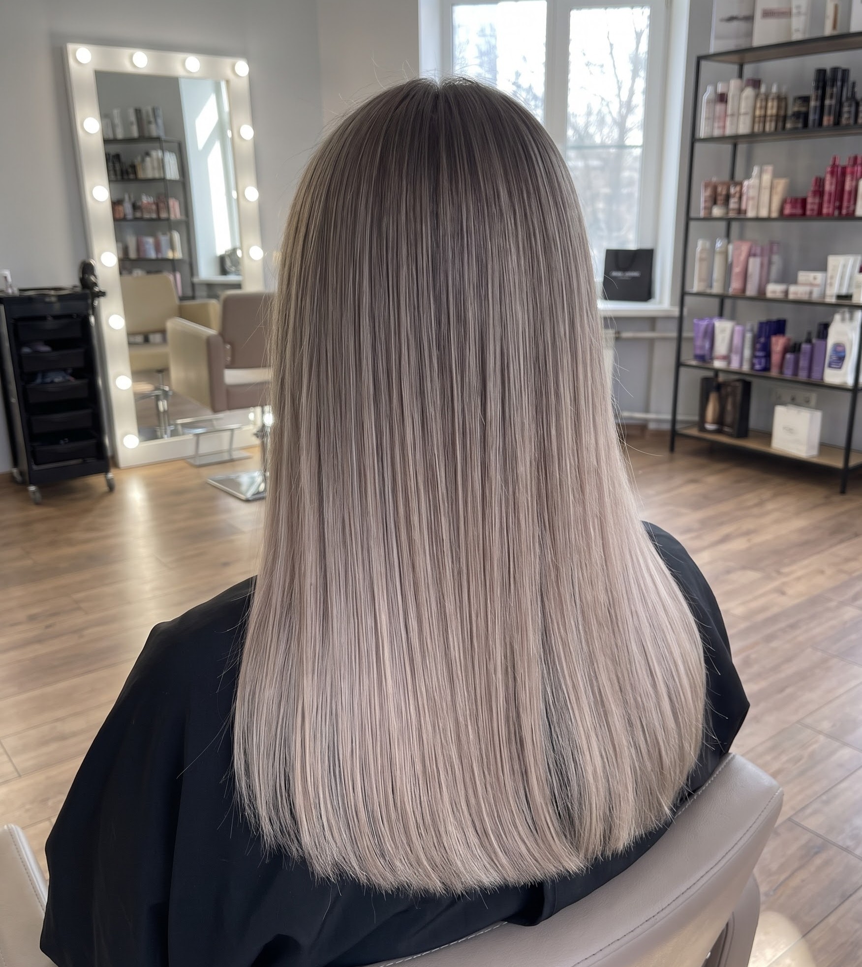 Ash bronde hair with a cool balayage, styled sleek and straight