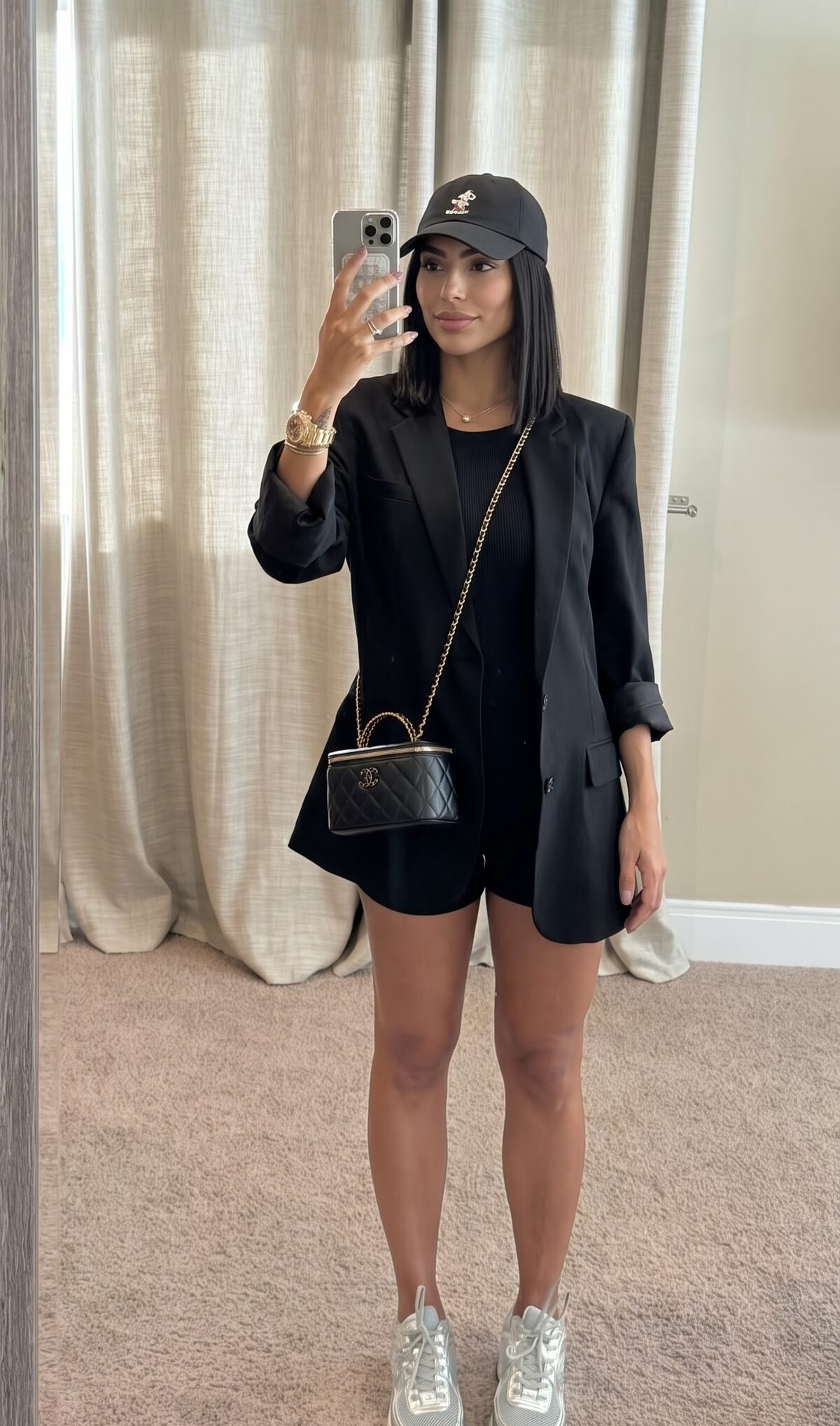 Black oversized blazer worn as a dress with romper and metallic sneakers