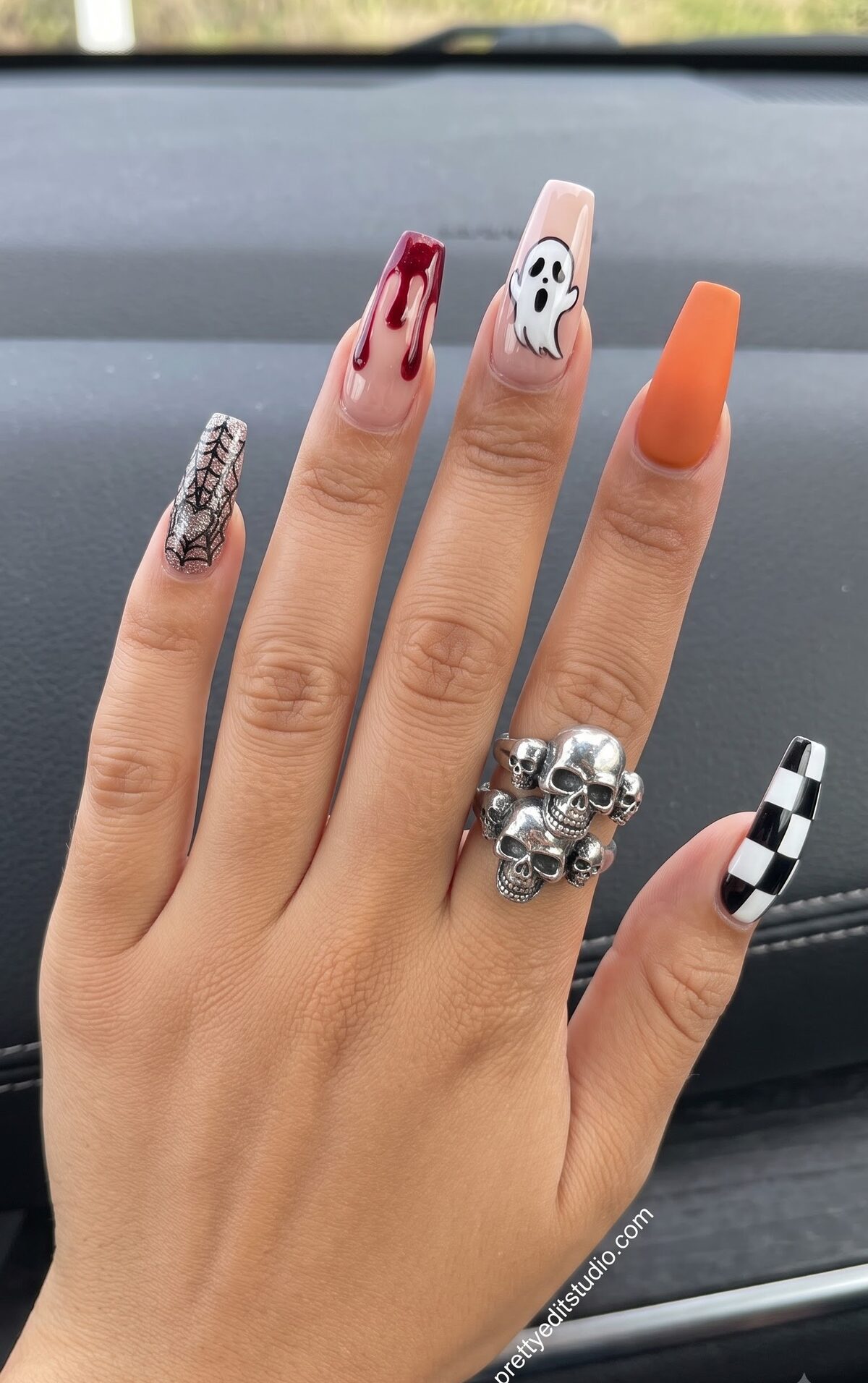 Mismatched Halloween nail designs with silver web glitter, blood drip, a ghost, orange matte and checkered nail