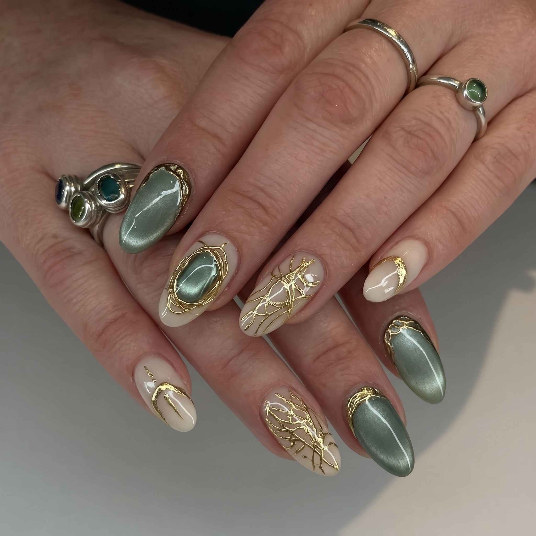 Sage green cat eye nails with delicate gold web line art