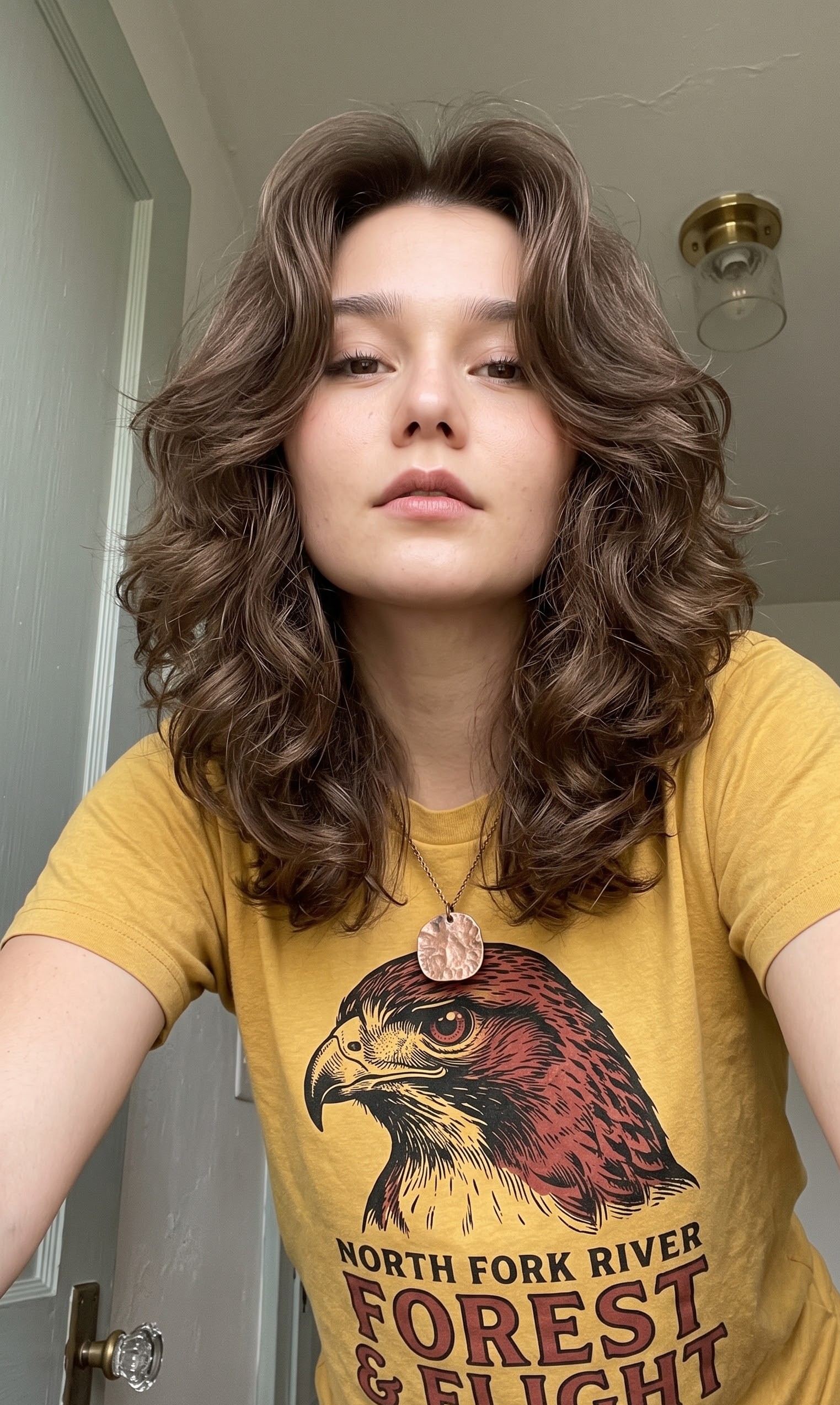 Curly brunette wolf cut with big 70s volume and rounded layers