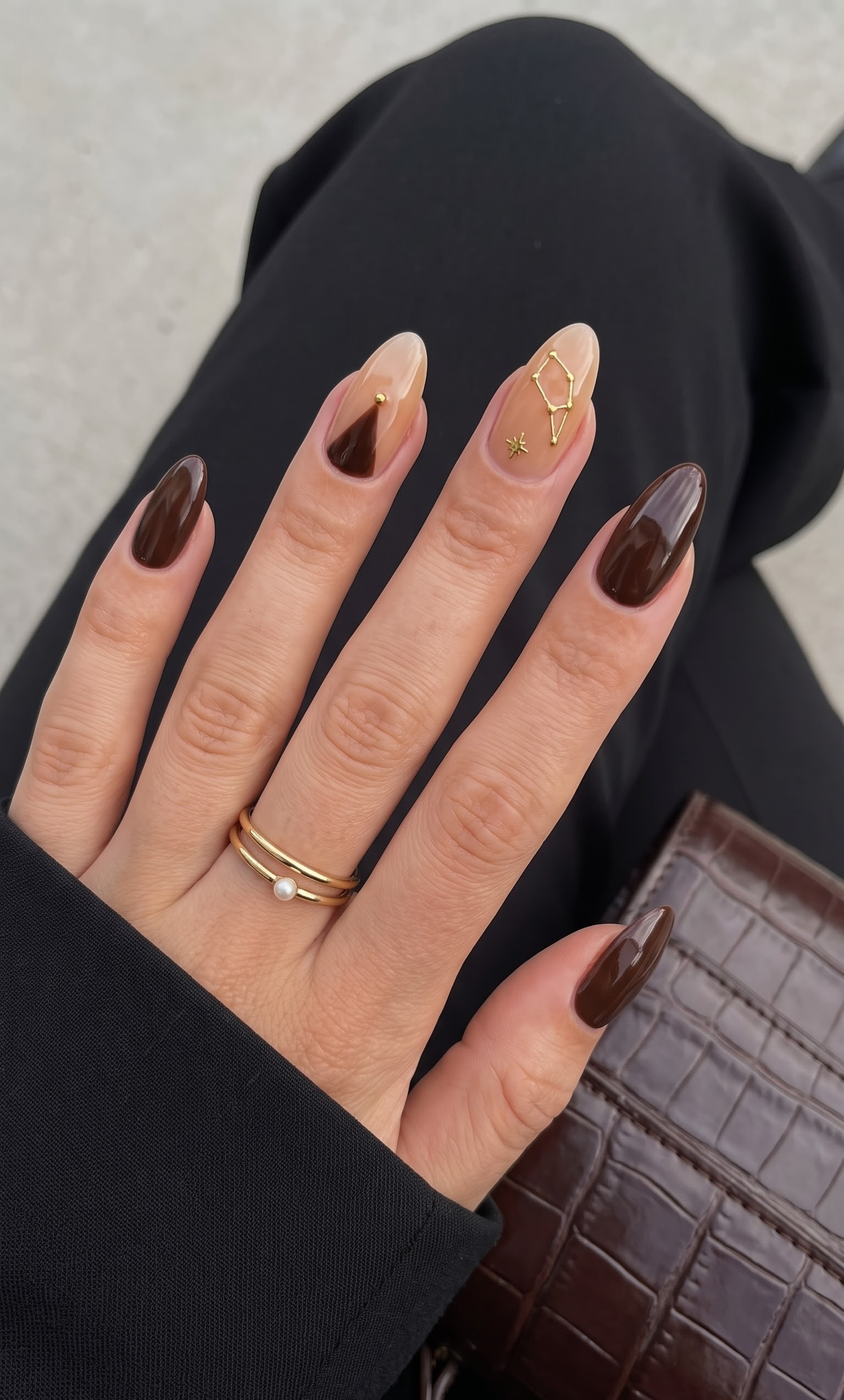 Glossy dark chocolate almond nails with a nude constellation accent nail