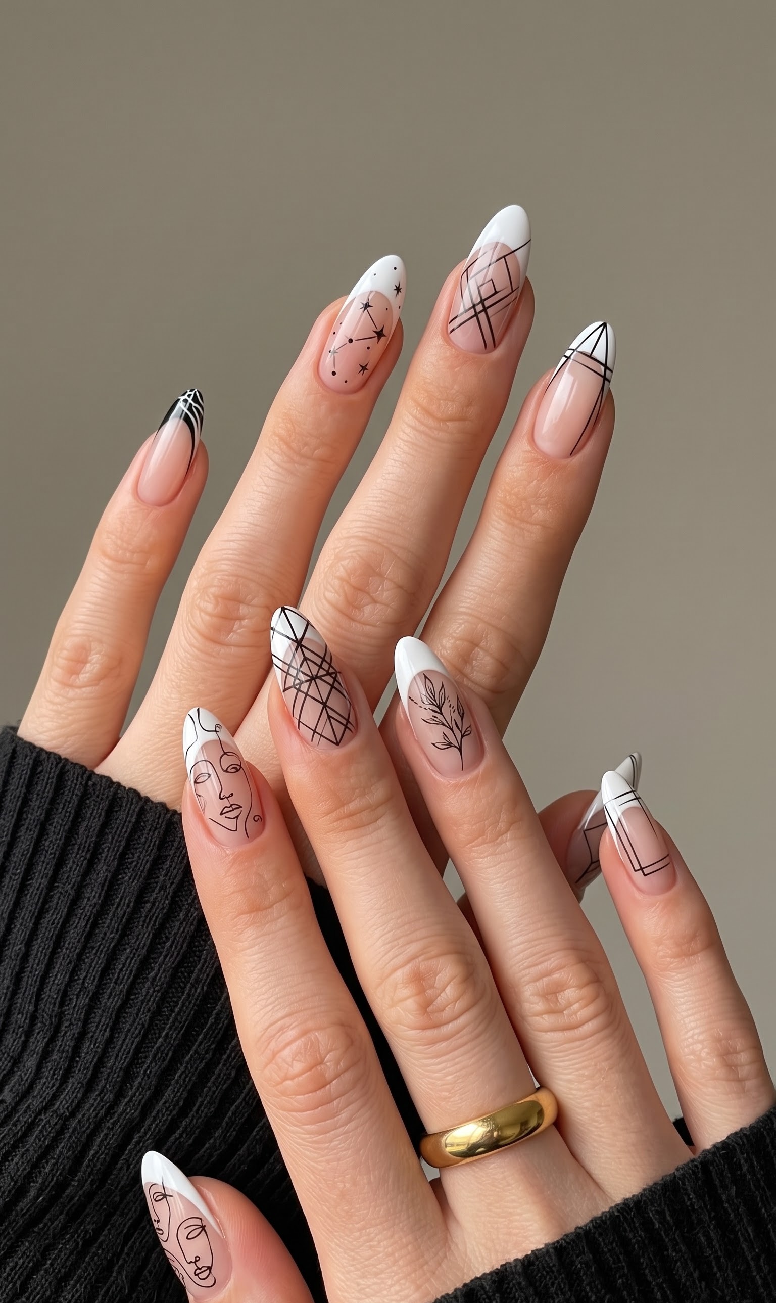 Nude almond nails with white french tips and black line art faces, constellations and geometric patterns