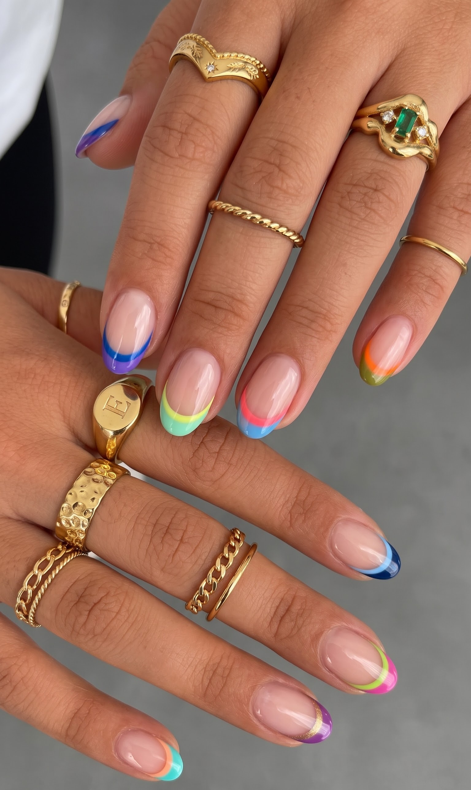 Nude oval nails with a different bright colored french tip on every finger