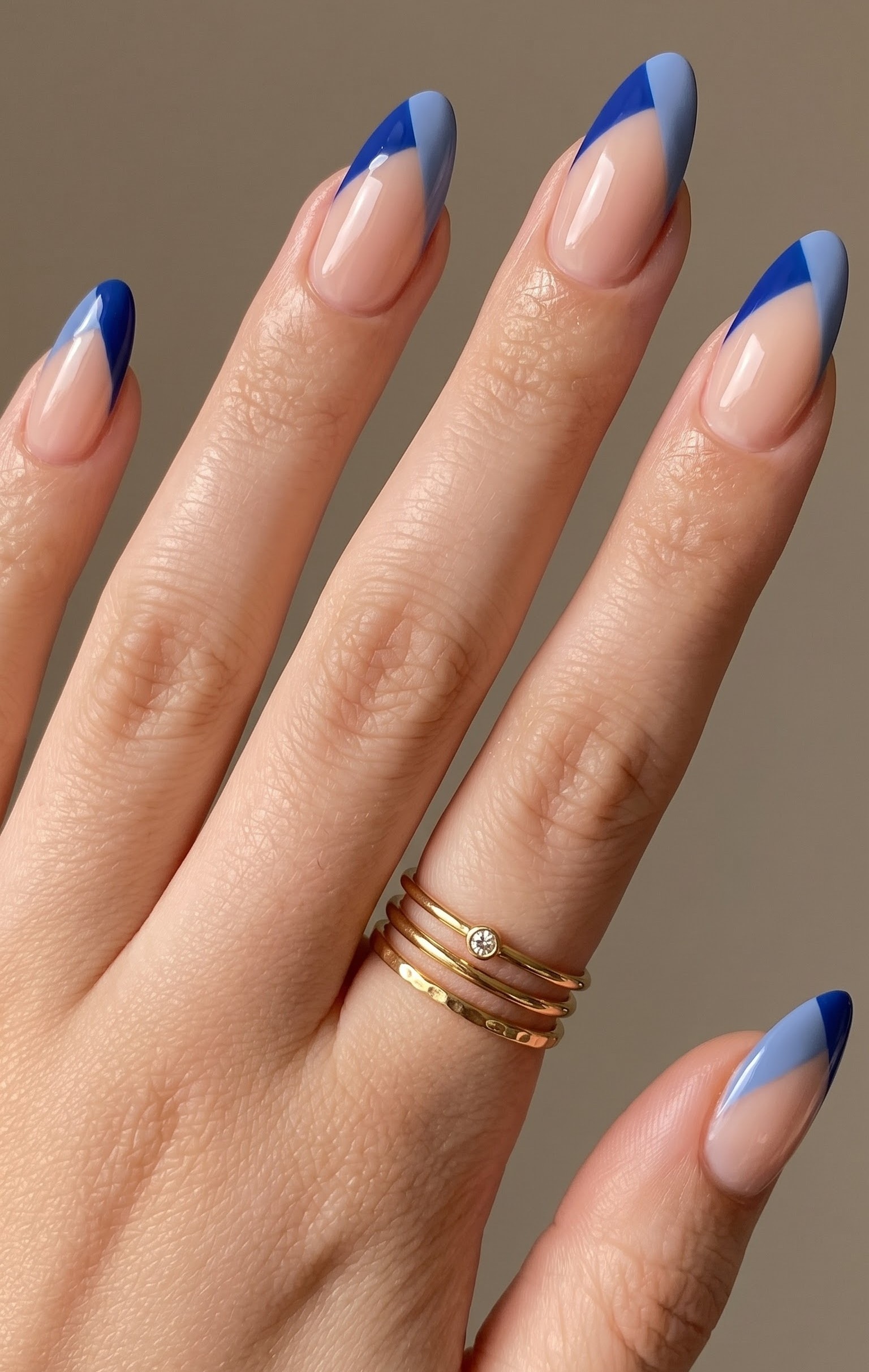 Nude almond nails with two-tone cobalt and sky blue diagonal french tips