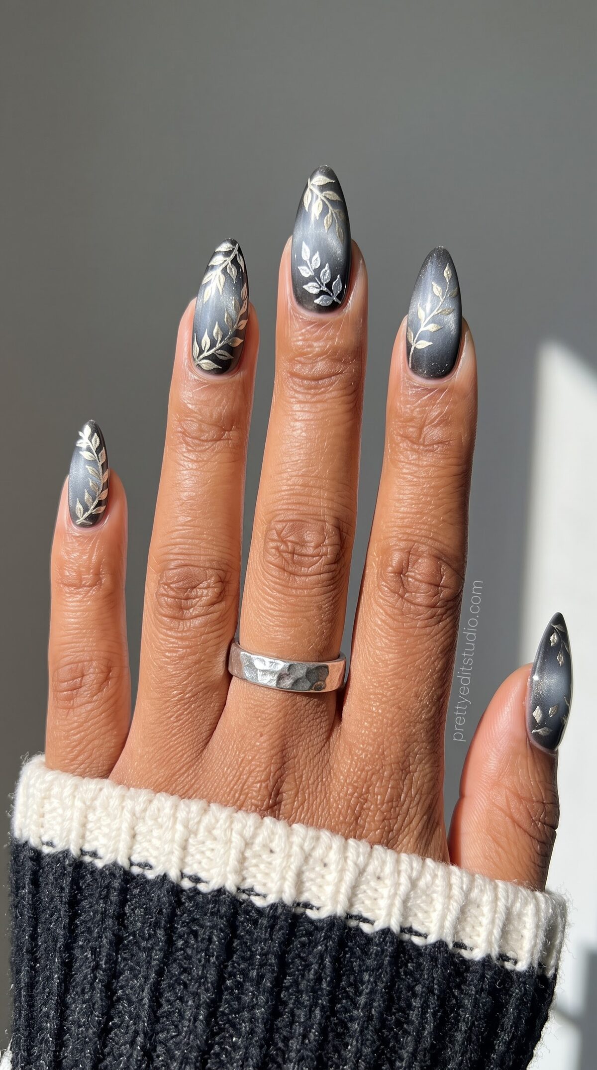 Matte grey nails with a delicate silver leaf and vine line art design