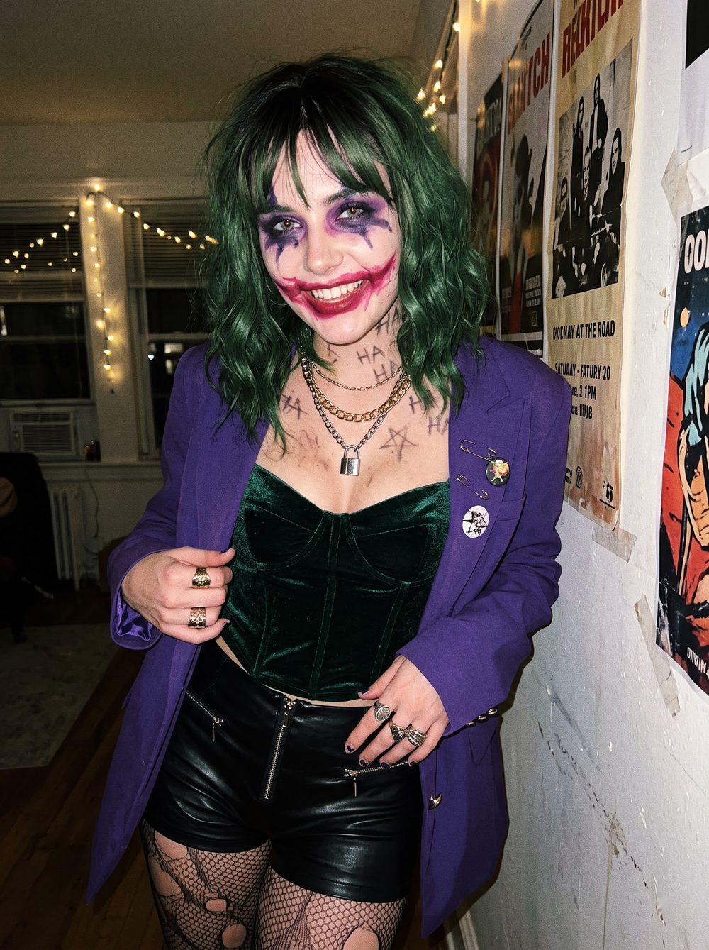 Woman in a Joker costume with green hair, a purple blazer, a green velvet corset, smeared red smile makeup and HA HA written on her neck