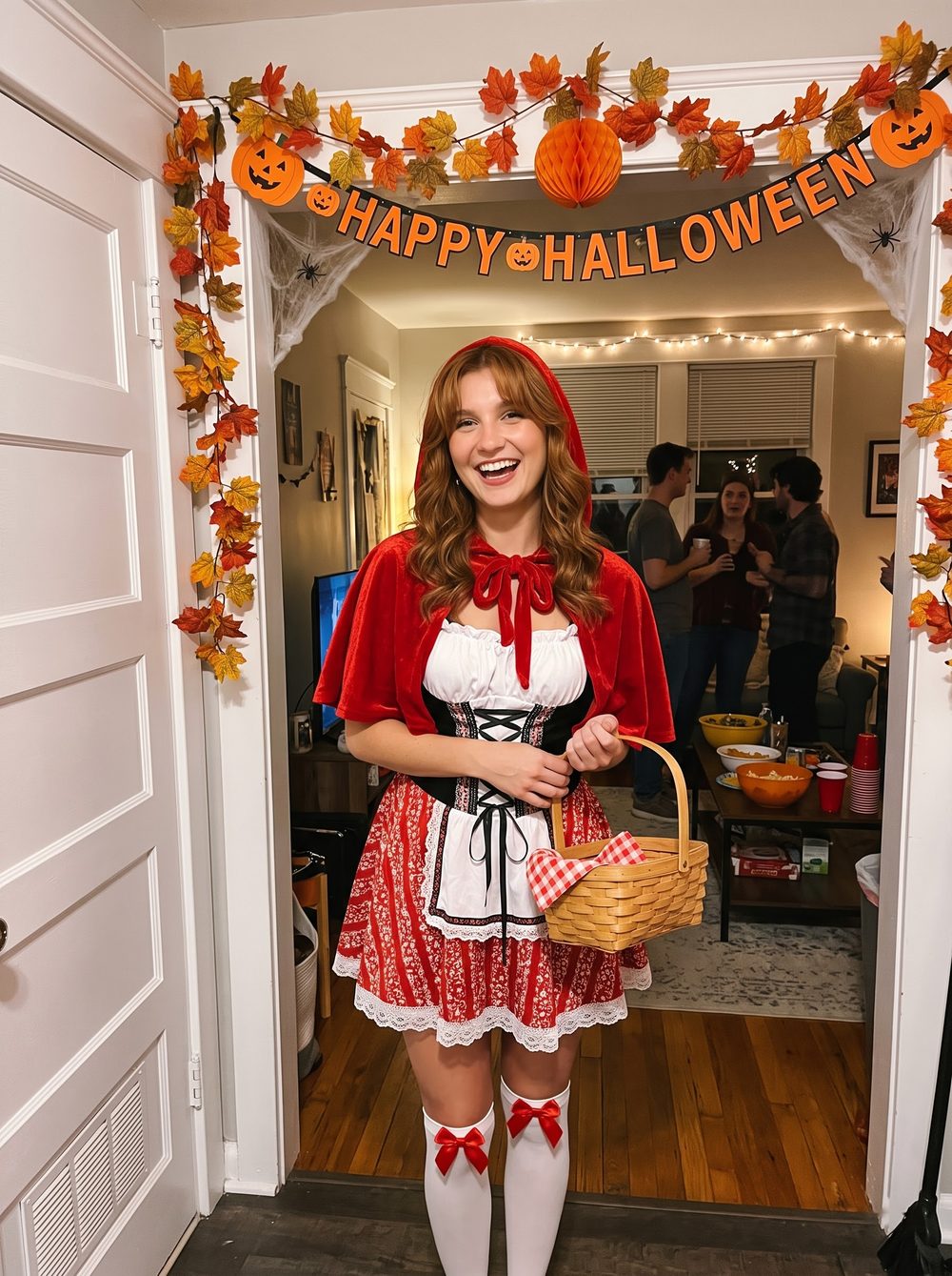 Woman in a Little Red Riding Hood costume with a red velvet hooded cape, black lace-up bodice and a picnic basket