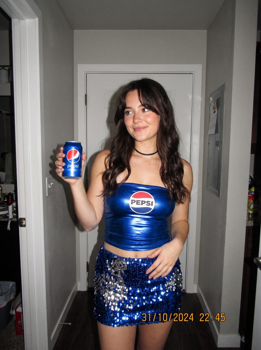 Woman in a Pepsi costume with a blue metallic tube top with the logo, a blue sequin skirt and a Pepsi can in her hand