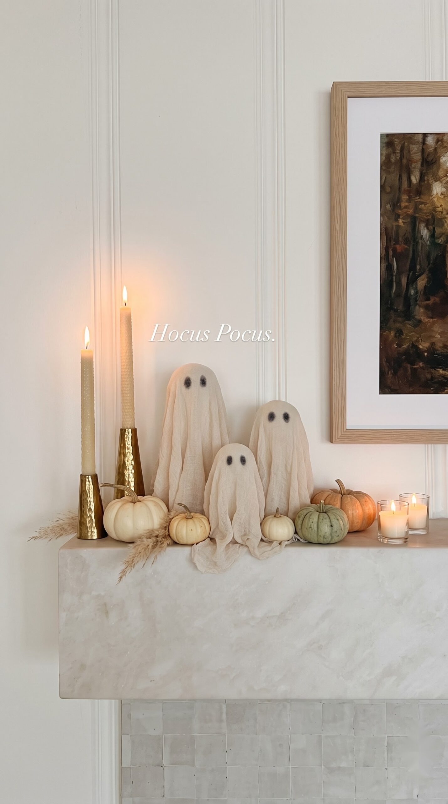 minimal fireplace mantel with cream fabric ghosts, taper candles, and heirloom pumpkins