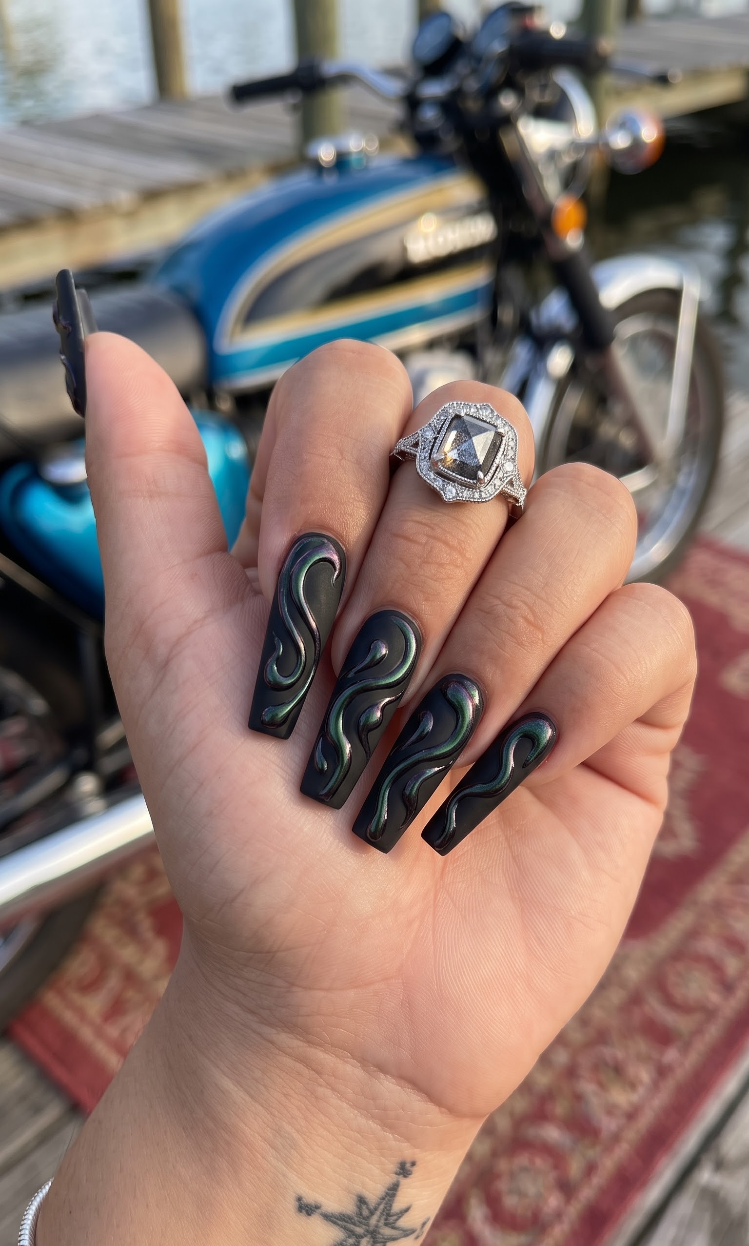 Matte black Halloween nails with iridescent abstract flame swirls