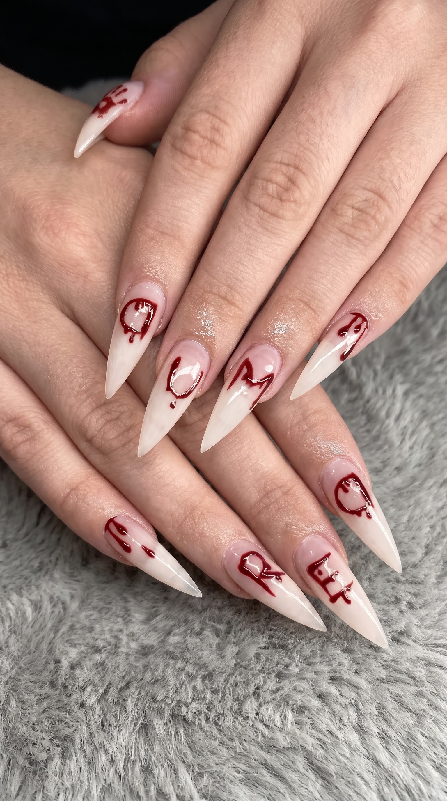 Nude Halloween nails spelling out a spooky word in dripping blood red lettering