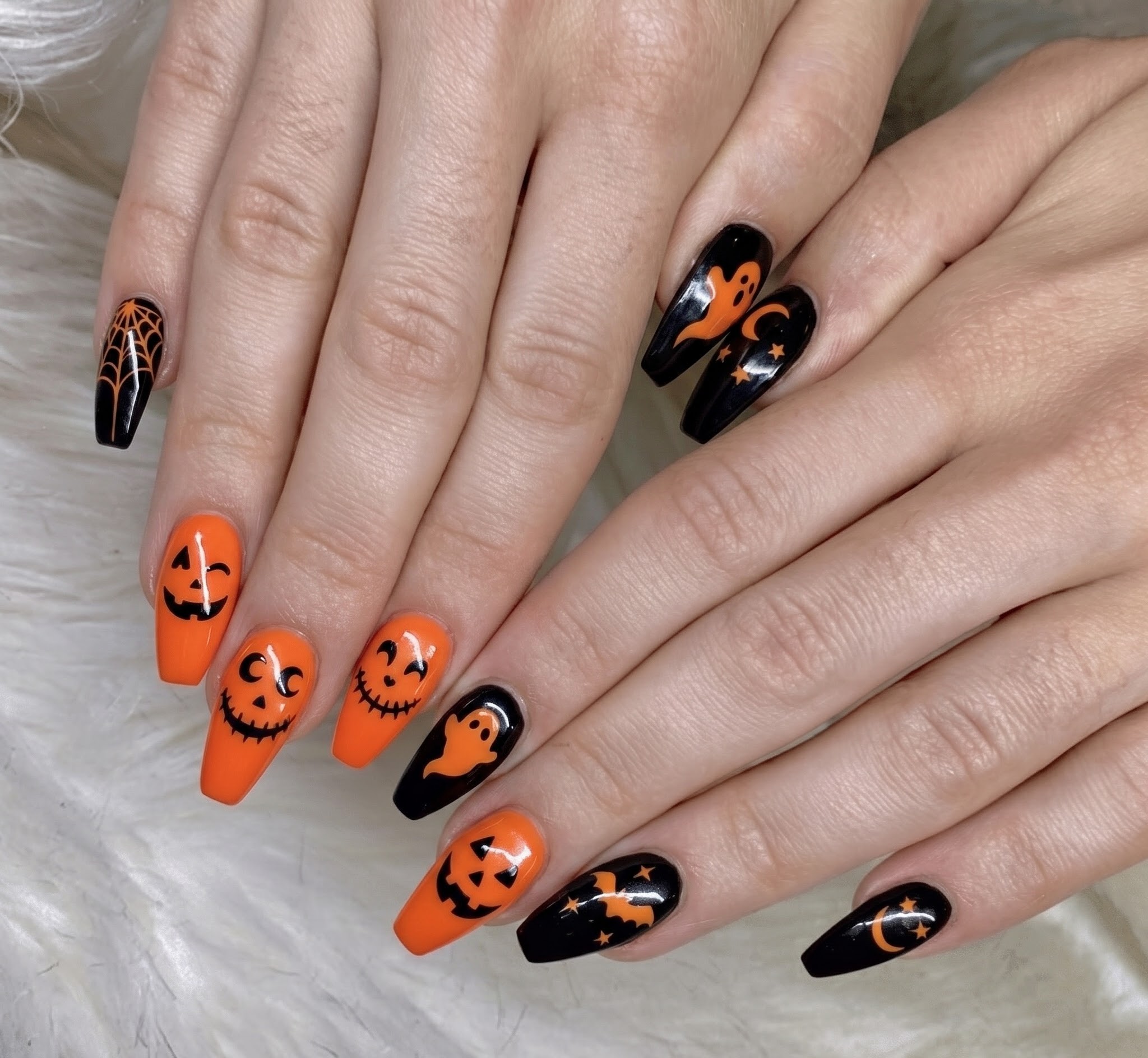 Orange and black Halloween nails with ghosts moons and stars