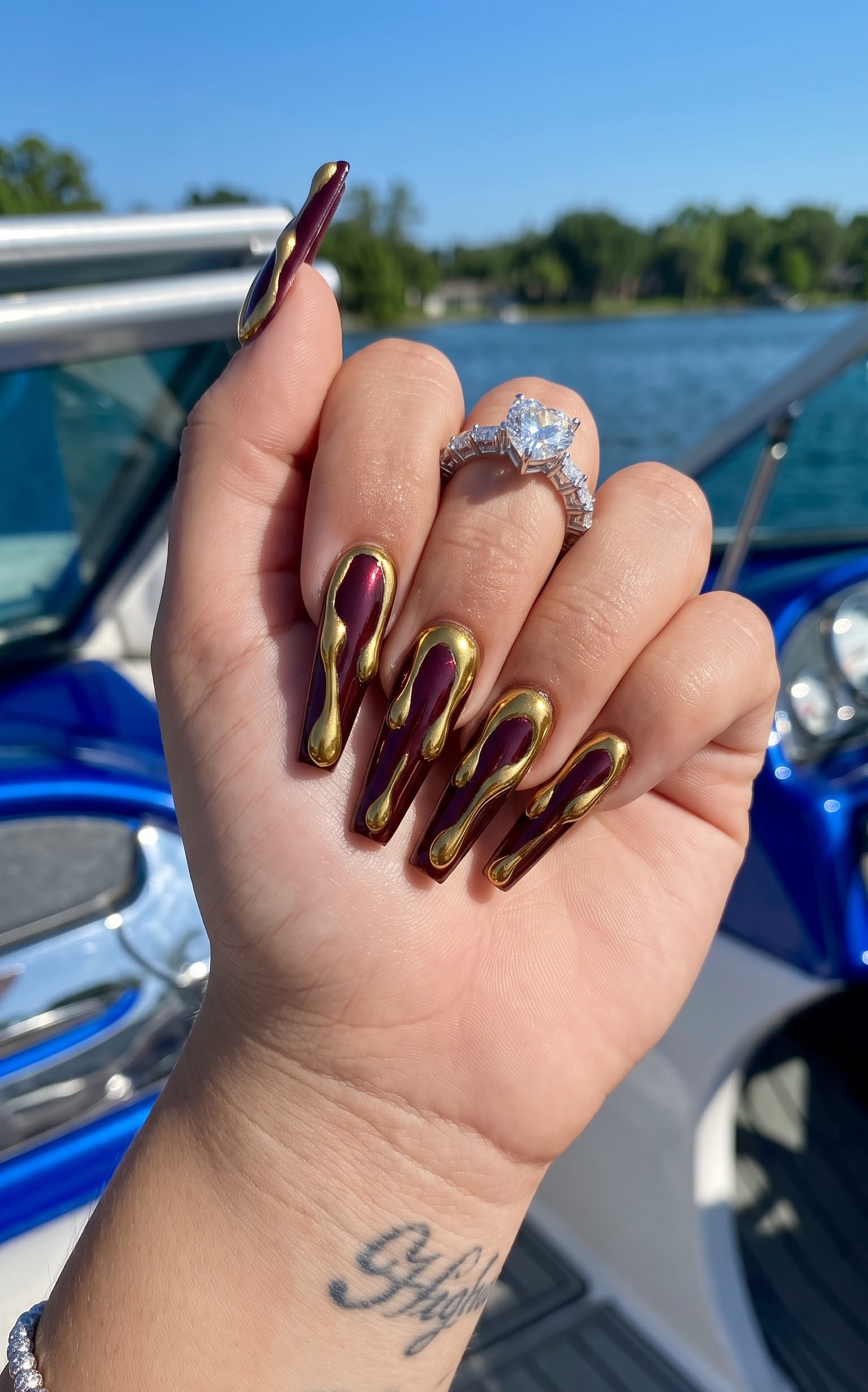 Deep burgundy chrome Halloween nails with gold chrome drip detailing