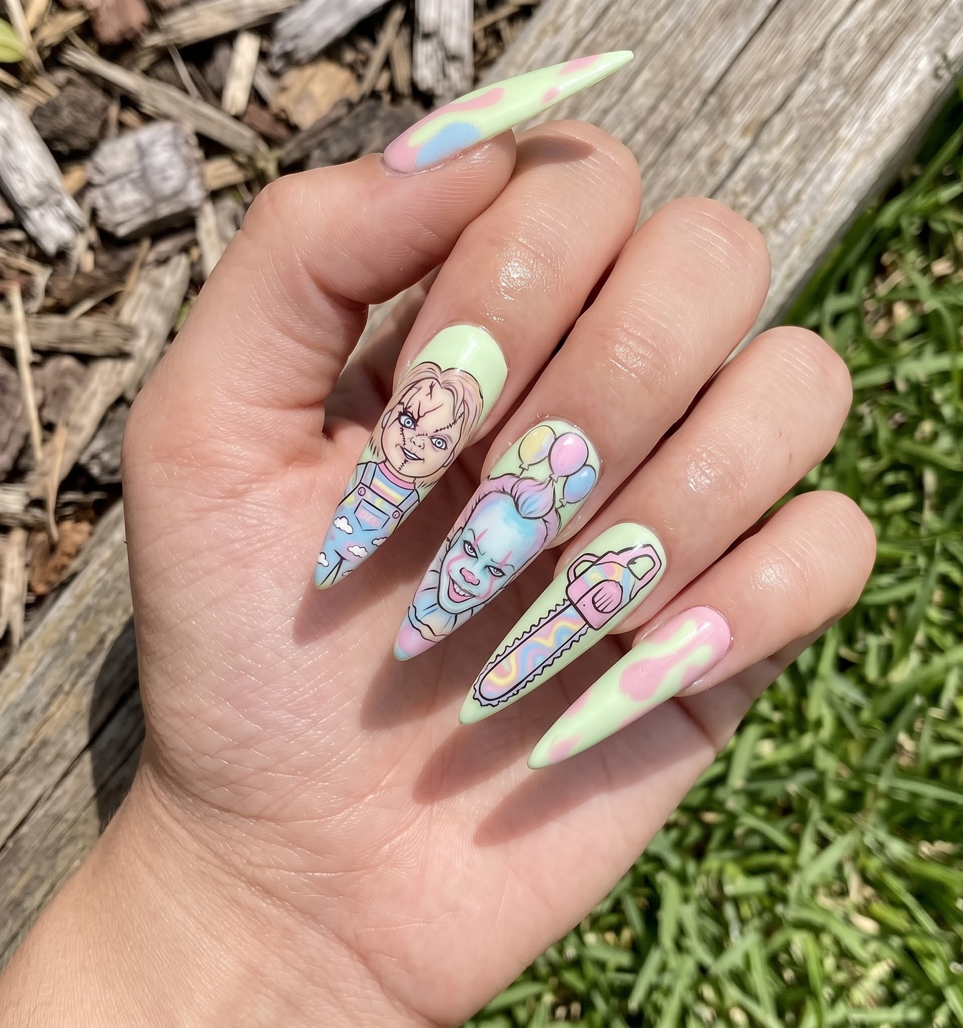 Pastel Halloween nails with cartoon Chucky and Pennywise horror characters