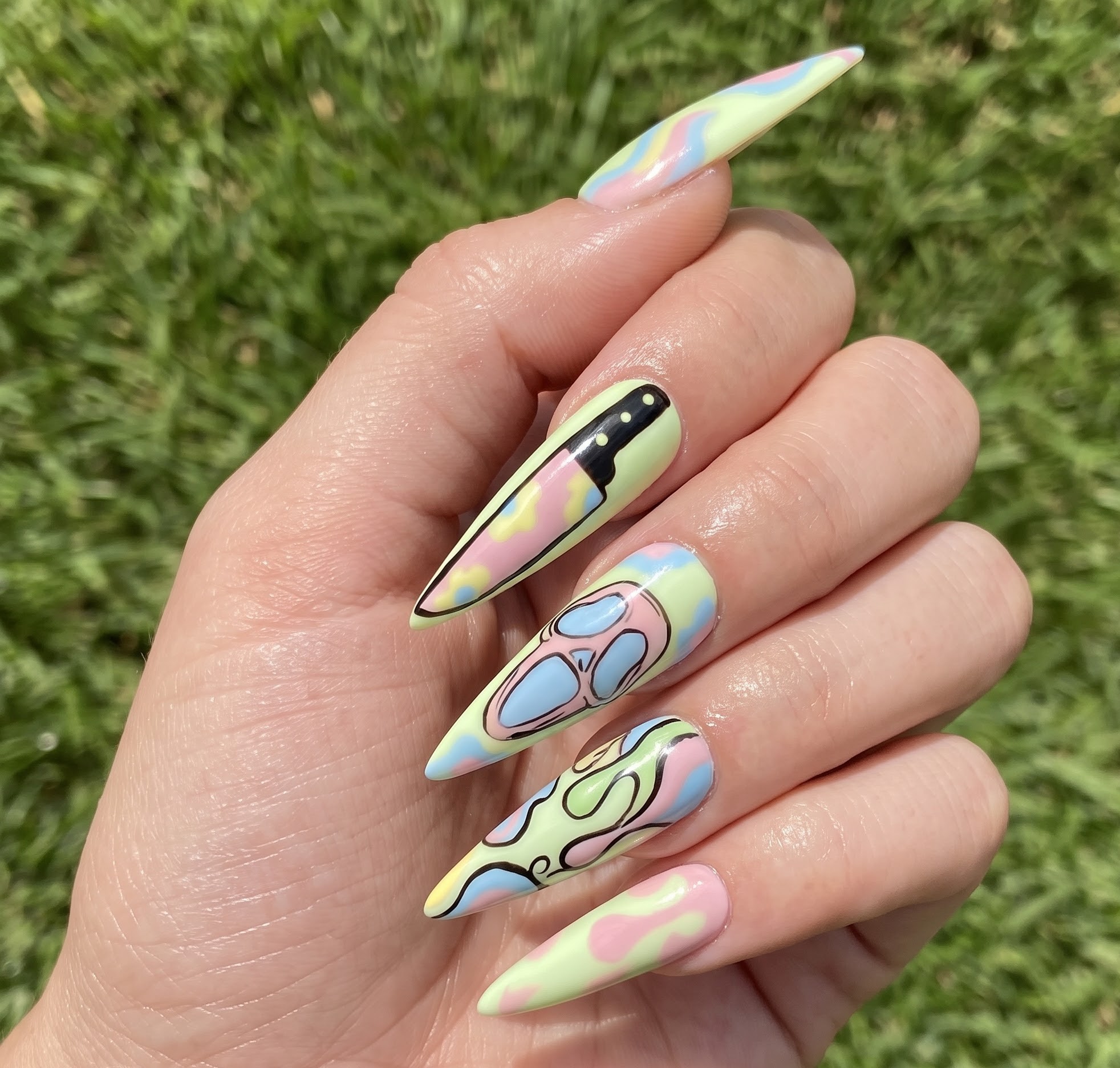 Pastel Halloween nails with a knife skull and swirl slasher theme