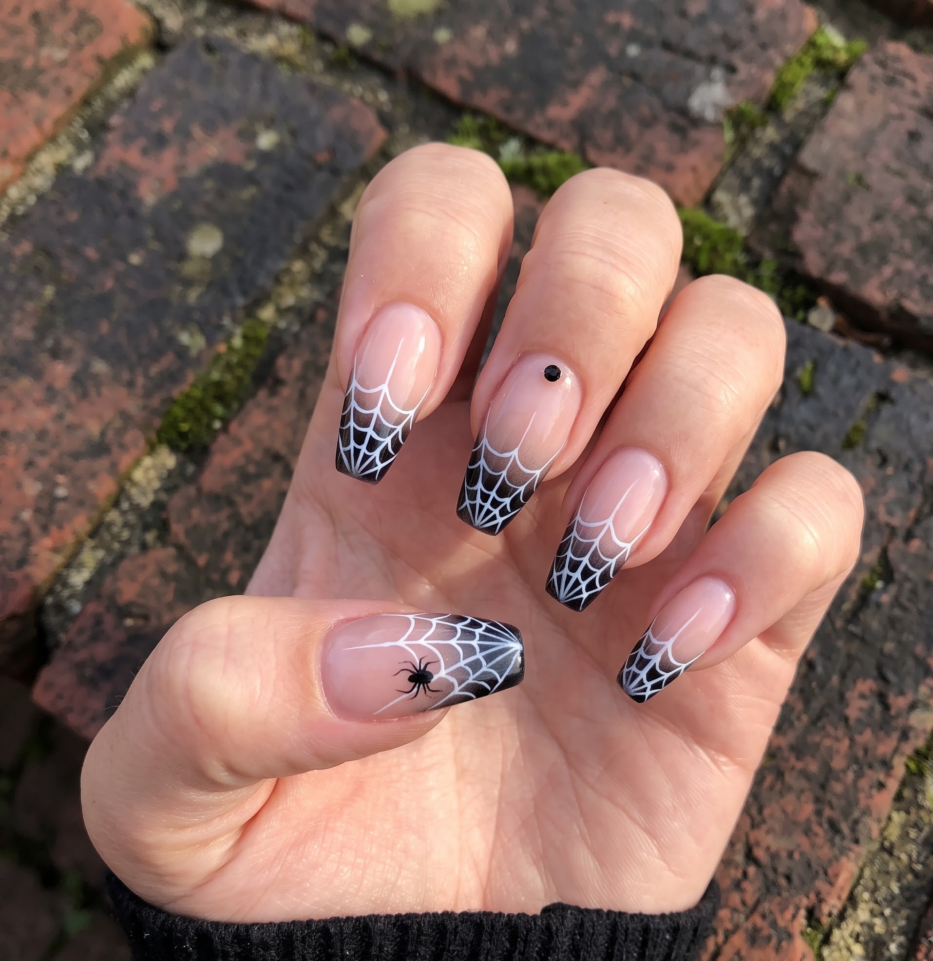 Ombre french tip Halloween nails with white spiderweb design and a spider accent