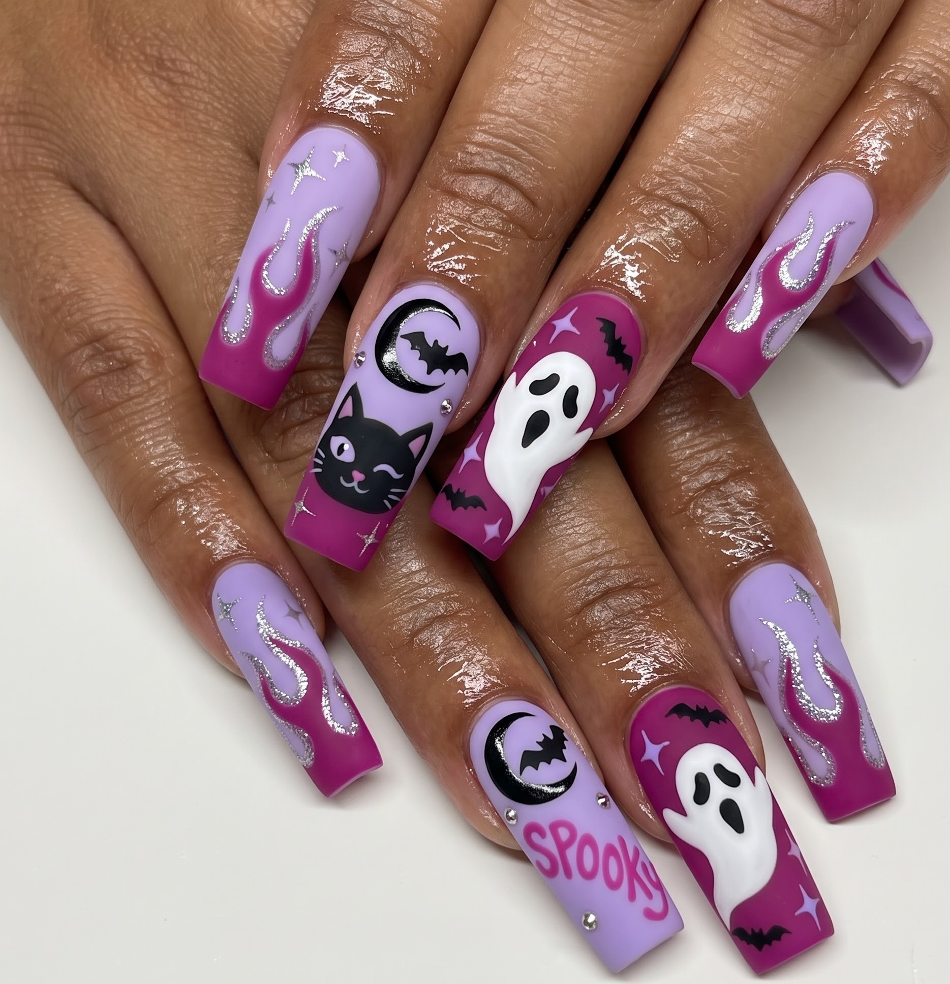 Purple and magenta Halloween nails with a black cat ghost and spooky lettering