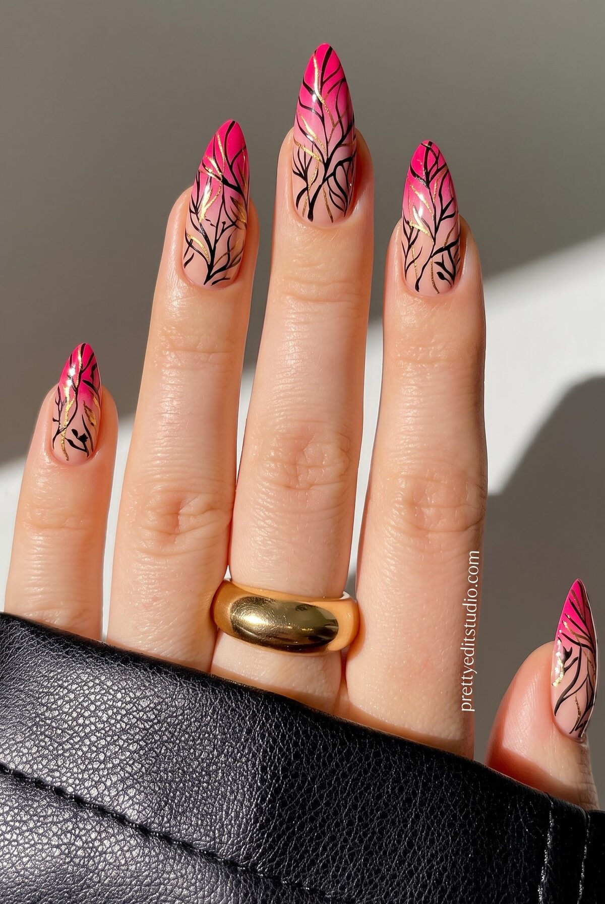 Hot pink ombre nails with black branch line art and gold foil accents
