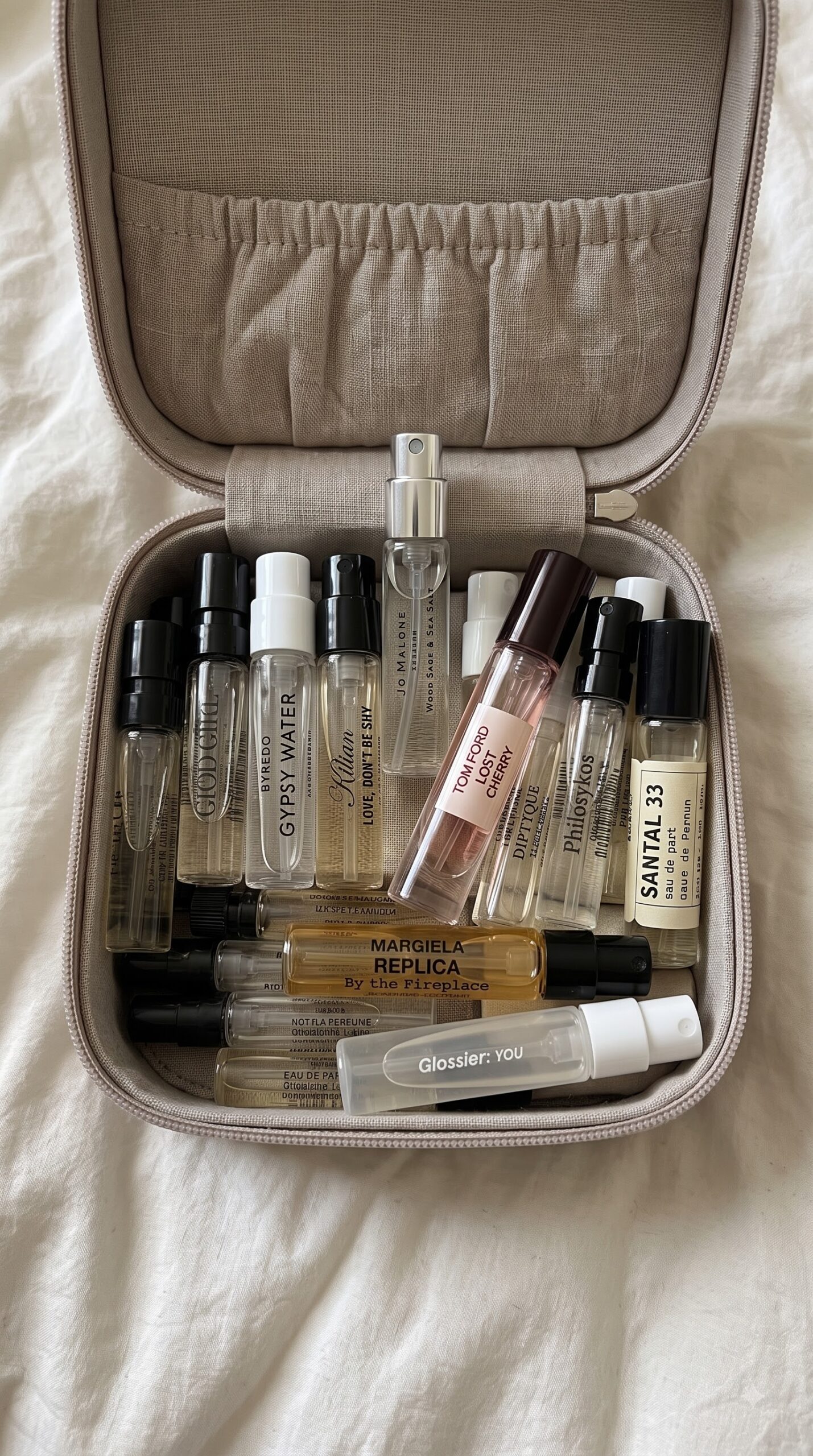 Travel perfume case filled with mini fragrance samples for reapplying scent on the go